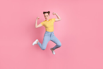 Full size portrait of energetic young person jumping flexing biceps isolated on pink color background