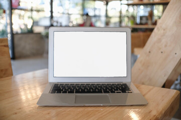 Laptop with Mock up blank screen on wooden table in front of coffeeshop cafe space for text. product display montage- technology concept