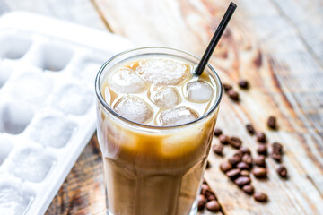 coffee ice cubes and beans with latte on wooden desk background