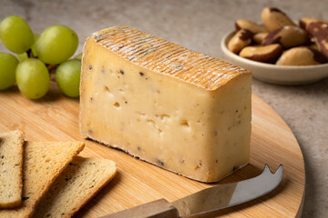 Cutting board with Italian Taleggio Tartufo cheese close up as a snack or appetizer 