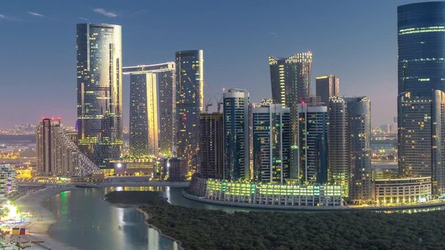 Buildings on Al Reem island in Abu Dhabi day to night timelapse from above.