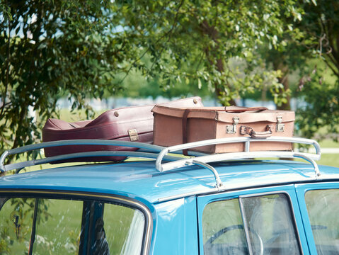 Vintage suitcases on the trunk of the roof of an old car