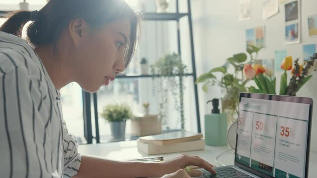 Young asia lady freelance focus on presentation work in laptop for account and finance project for remote meeting with company at house. Girl student learn online at home. Work from home concept.
