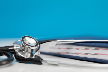 Close-up view of a stethoscope lying on a desk next to a computer keyboard. Close-up view.