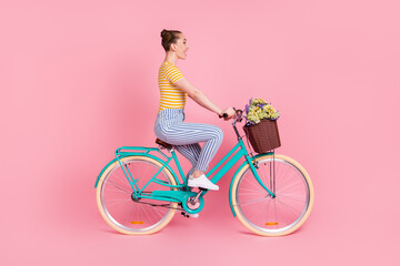 Full size profile photo of optimistic nice brunette ride bicycle wear t-shirt pants isolated on pink background
