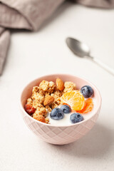 Oatmeal granola with yogurt, berries, fruits and nuts in a bowl on the table. Healthy breakfast