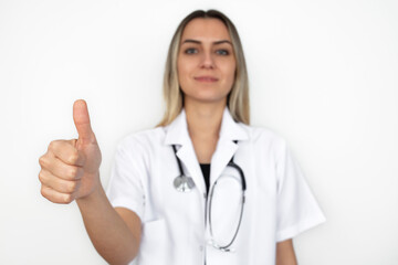 young female doctor looking at camera showing thumbs up. Best treatment and patient care concept.