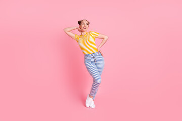Fototapeta na wymiar Full size photo of optimistic nice brunette lady look empty space wear t-shirt pants isolated on pink background