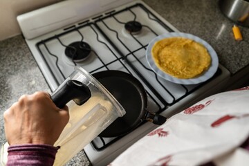 Fototapeta na wymiar Woman cooking pancakes at home with a homemade recipe