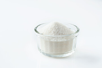 White sugar in glass bowl isolated on white background. Selective focus.