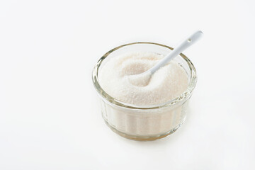 White sugar in glass bowl isolated on white background. Selective focus.