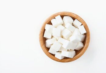 White sugar cube in bamboo bowl isolated on white background. Top view.