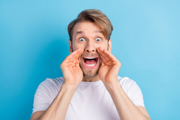 Photo of impressed person arms near open mouth yell tell loud look camera isolated on blue color background