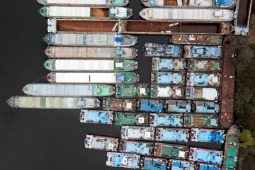 .Lots of abandoned transport barges moored side by side at the wharf. River transport industry.