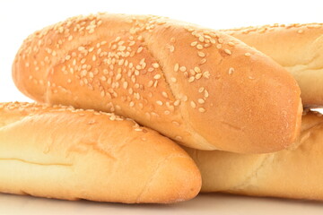Several fragrant bagels sprinkled with sesame seeds, close-up, isolated on white.
