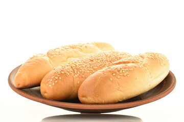 Three fragrant bagels on a clay plate, close-up, isolated on white.