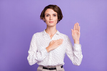 Portrait of young girl concentrated face arm on heart look camera isolated on purple color...