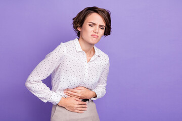Photo of negative young person closed eyes hands on stomach bad mood isolated on violet color...