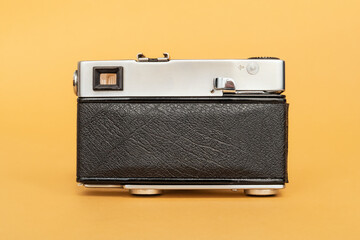 Old film camera on yellow background