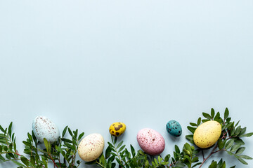 Frame of Easter eggs with spring branches and green leaves. Veiw from above
