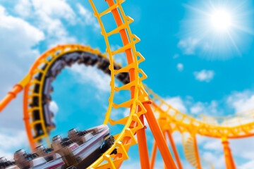 most exciting roller coaster drive high to summer sky at theme park, people excited fun and joyful...