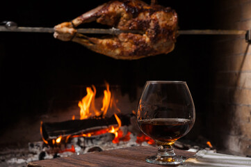 the back of a lamb on a spit with a glass of brandy