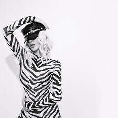Sensual sexy androgenic model in freak stylish zebra print clothes and leather trendy black cap...