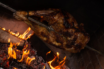 the back of a lamb on a spit with a glass of brandy