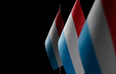 Small national flags of the Luxembourg on a black background