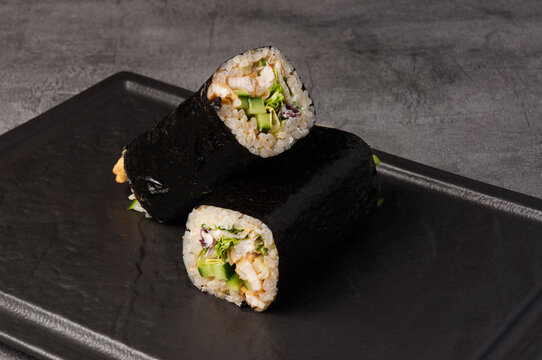 sushirrito with chicken and vegetables on a dark stone