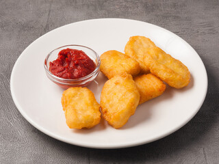 nuggets with tomato sauce on a white plate. concept: fast food