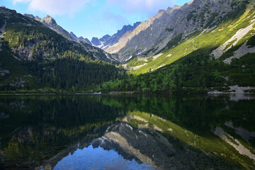 Fototapeta na wymiar The beautiful lake Popradske pleso in the High Tatras in the evening sun with a reflection of the mountains. Slovakia.