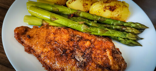Paniertes Schnitzel mit grünem Spargel und Kartoffeln