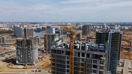 Fototapeta premium Modern urban development. Construction site with multi-storey buildings under construction. Construction work is underway. Aerial photography.