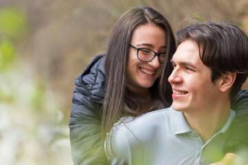 Fototapeta premium Close up of smiling young couple having an great time outdoors,side view with bllured backgound