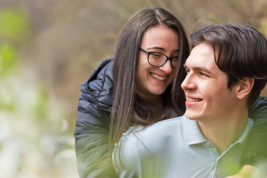 Close up of smiling young couple having an great time outdoors,side view with bllured backgound