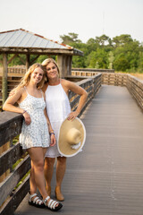 Mother Daughter with hat on boardwalk in white dresses