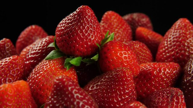 Bunch of ripe strawberries in close up on black background
