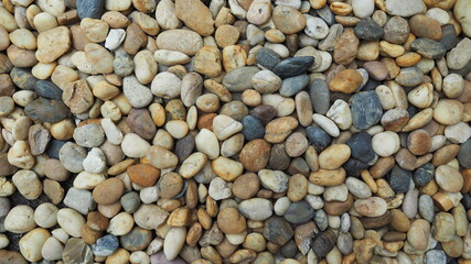 Pebble stone or river stone on floor for garden decoration. Landscape  design , garden idea , simplicity stone background concept. Flat lay texture in daylight