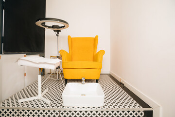 Yellow chair in pedicure salon. organization of work place for the master of foot and nail care.