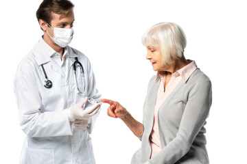 Elderly patient pointing at jar with vaccine in hand of doctor in protective mask isolated on white