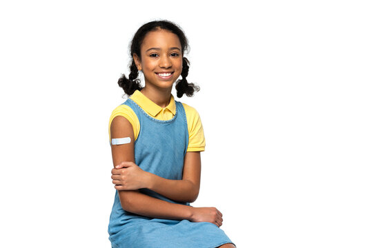 Cheerful african american kid with adhesive patch on arm looking at camera isolated on white