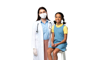 Doctor in medical mask standing near smiling african american kid isolated on white