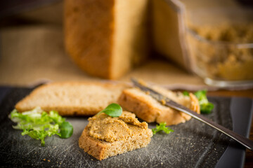 homemade meat pate with bread on a wooden table