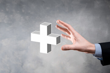 Businessman hold 3D plus icon, man hold in hand offer positive thing such as profit, benefits, development, CSR represented by plus sign.The hand shows the plus sign