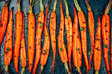 Roasted Carrots. Baked baby carrots with thyme in a black tray