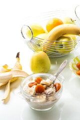 cooked boiled sweet oatmeal with with dried apricots and bananas in a bowl
