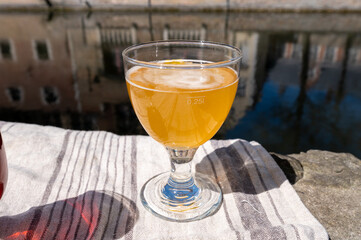 Tasting of Belgian beer on open cafe or bistro terrace with view on medieval houses and canals in Bruges, Belgium