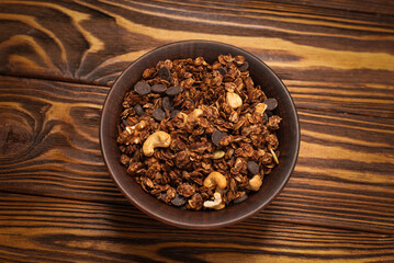 Chocolate granola cereal with nuts in a bowl.