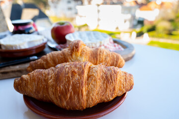 French breakfast with fresh baked croissants and cheeses from Normandy, camembert and neufchatel served outdoor with nice city view